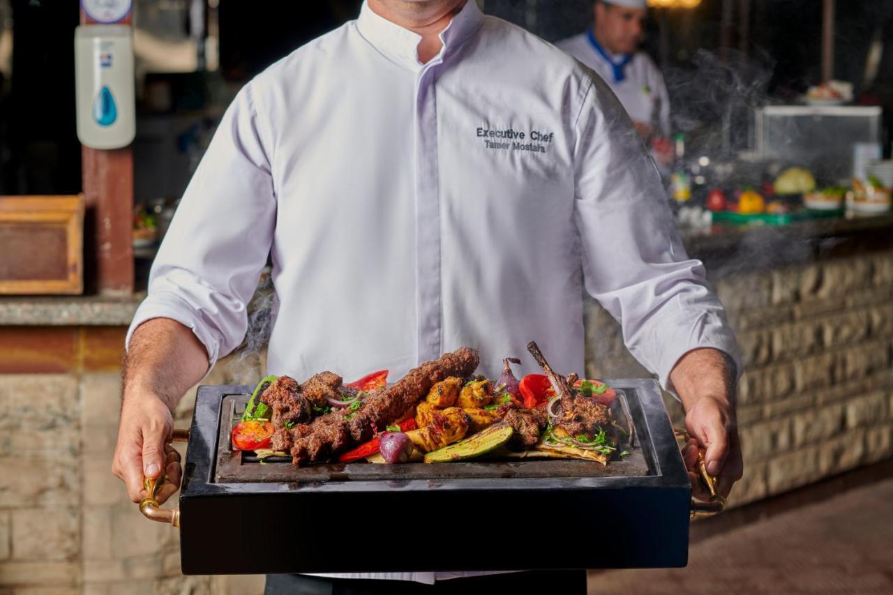 Maritim Jolie Ville Resort & Casino Sarm es-Sejk Kültér fotó A chef holding a serving dish